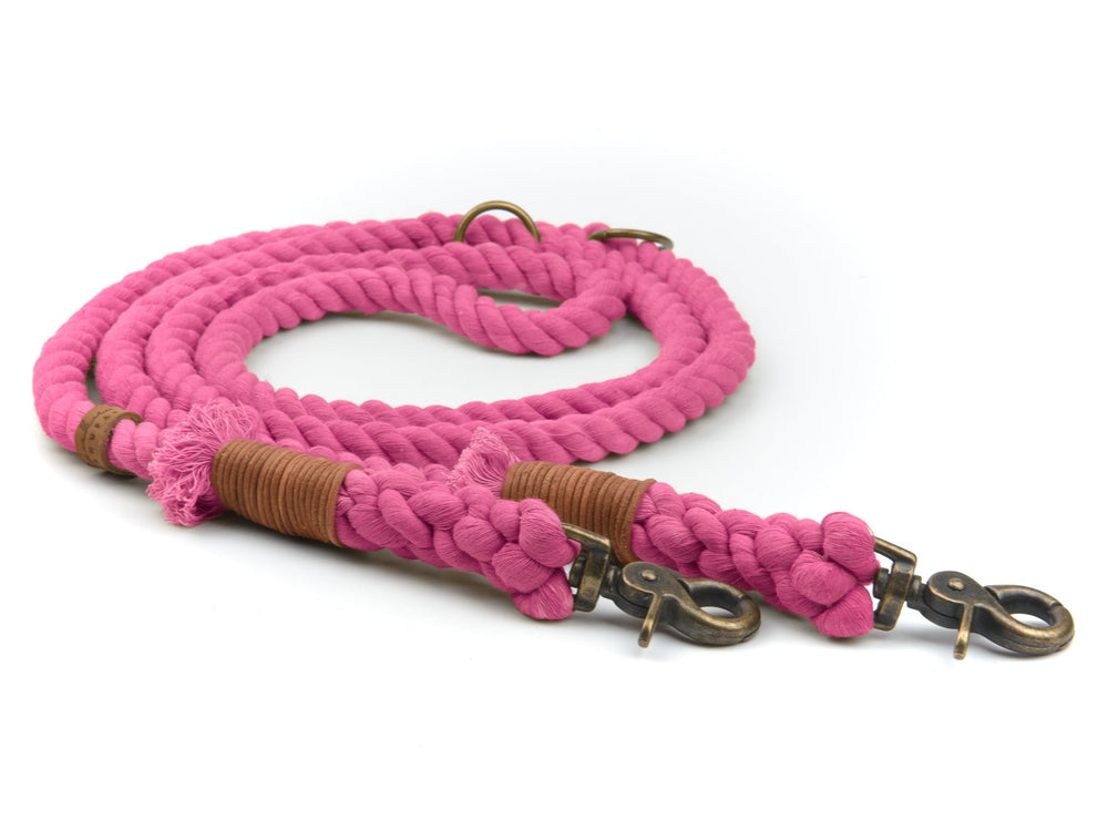Pinkfarbene geflochtene Hundeleine mit Lederverzierungen und zwei Metallkarabinerhaken für sicheres Führen.