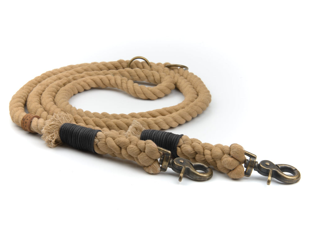 Beige geflochtene Tauleine mit robusten Metallverschlüssen und schwarzer Stoffumwicklung, ideal für Hunde.