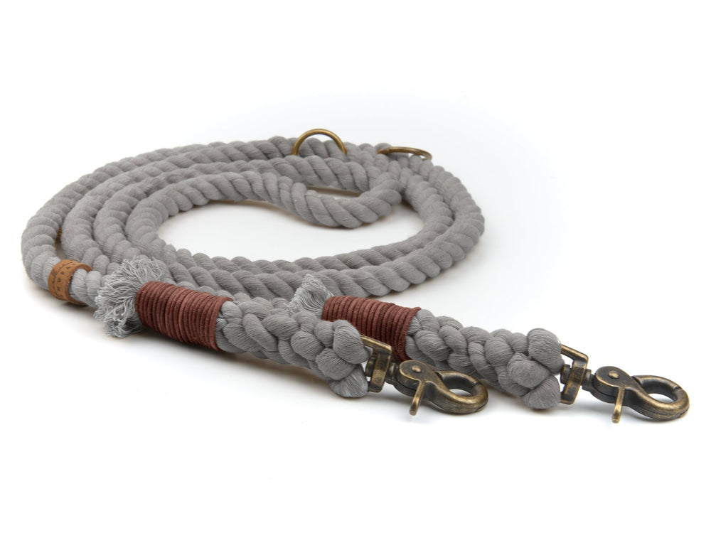 Graue geflochtene Hundeleine mit robusten Karabinern und braunen Akzenten für sicheres Spazierengehen.