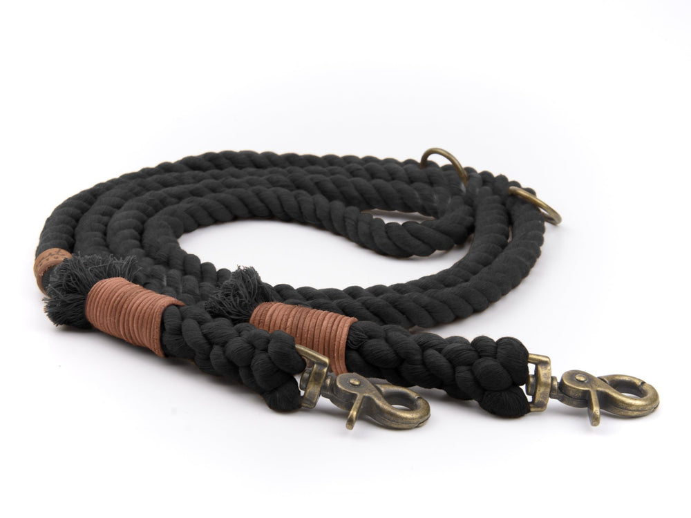 Schwarzes geflochtenes Seil mit goldfarbenen Haken und braunen Lederakzenten für eine stilvolle Tauleine.