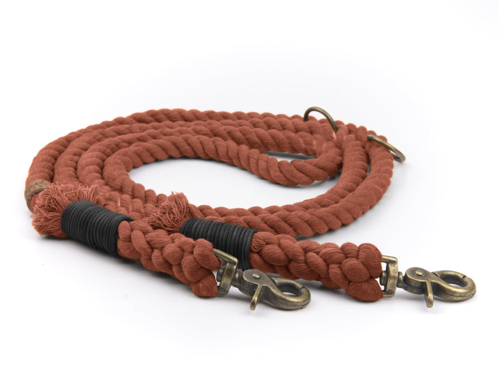 Geflochtene rotbraune Tauleine mit zwei Karabinerhaken und strukturierter Oberfläche, ideal für Hundebesitzer.