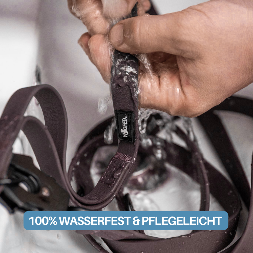 Hand reinigt die wasserdichte Führleine WOOFLEX® Pro unter fließendem Wasser, ideal für aktive Hunde.