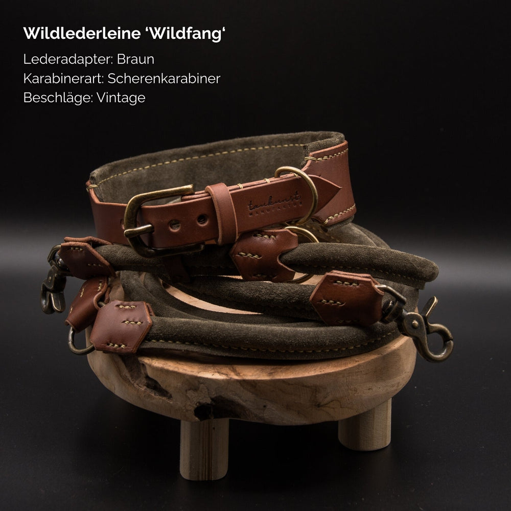 "Wildfang Wildlederleine in Braun mit hellen Lederadaptern und vintage Scherenkarabiner auf Holzuntergrund"