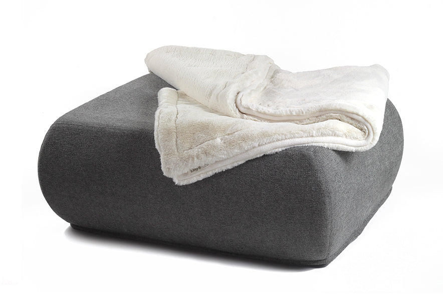 Graues quadratisches Kissen mit abgerundeten Ecken und flauschiger Decke auf weißem Hintergrund.