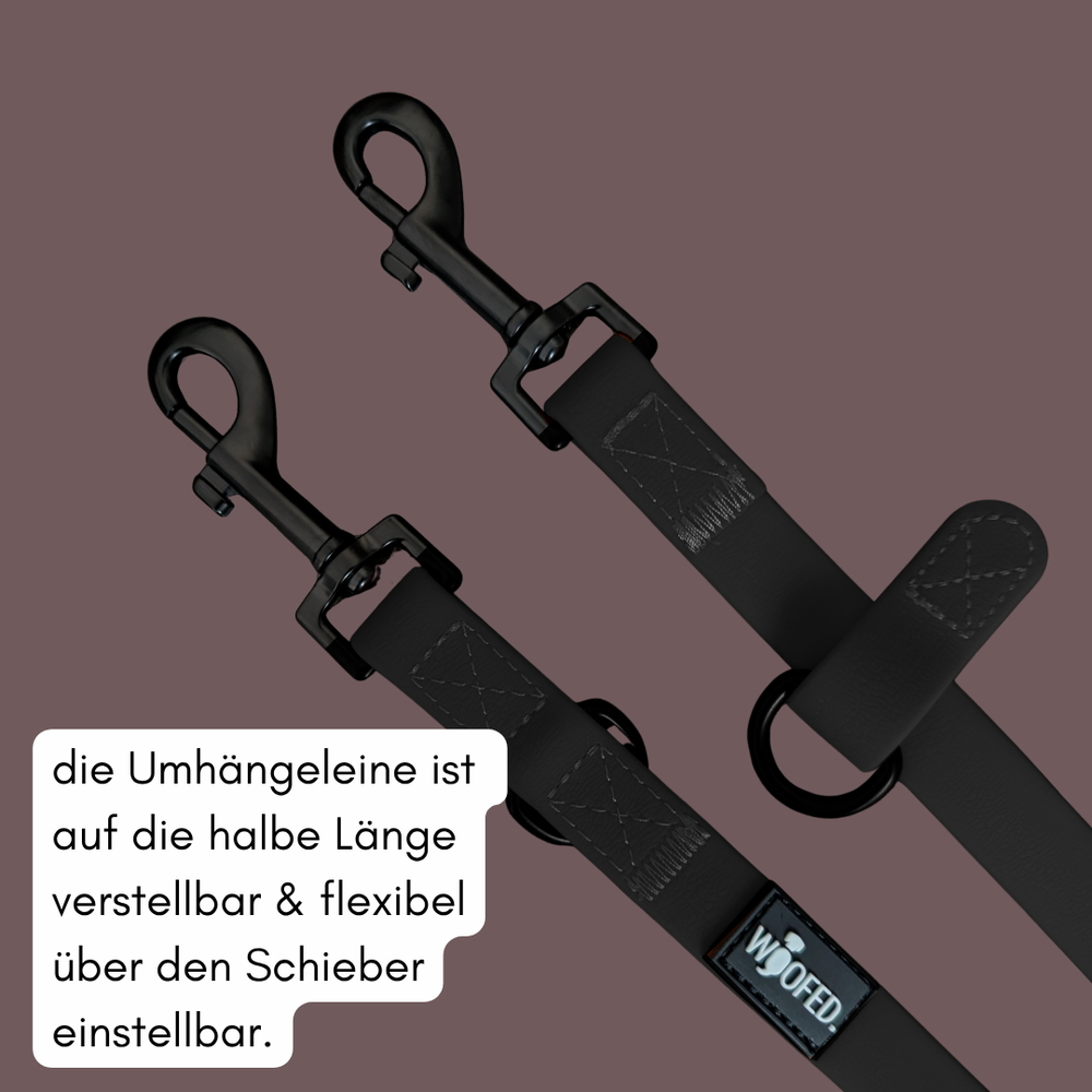 Schwarze Umhängeleine WOOFLEX® Classic mit zwei Karabinerhaken und verstellbarem Schieber, WOOFED-Label sichtbar.