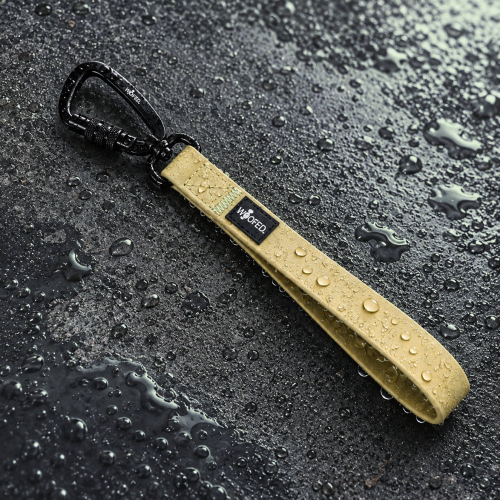 Wasserdichter Hundeleinengriff WOOFLEX® in Gelb mit schwarzem Karabiner und Wassertropfen, ideal für jedes Wetter.