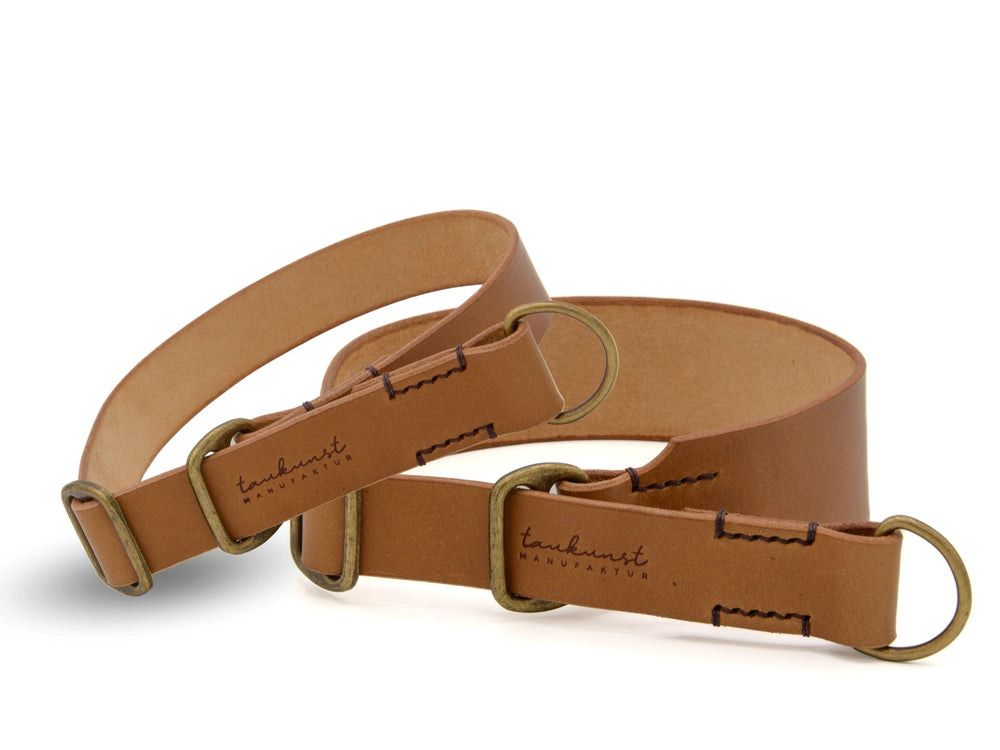 Zwei hellbraune Leder Gürtel mit Metallringen und eingeprägtem "tanukunst"-Schriftzug, perfekte Accessoires für jeden Stil.