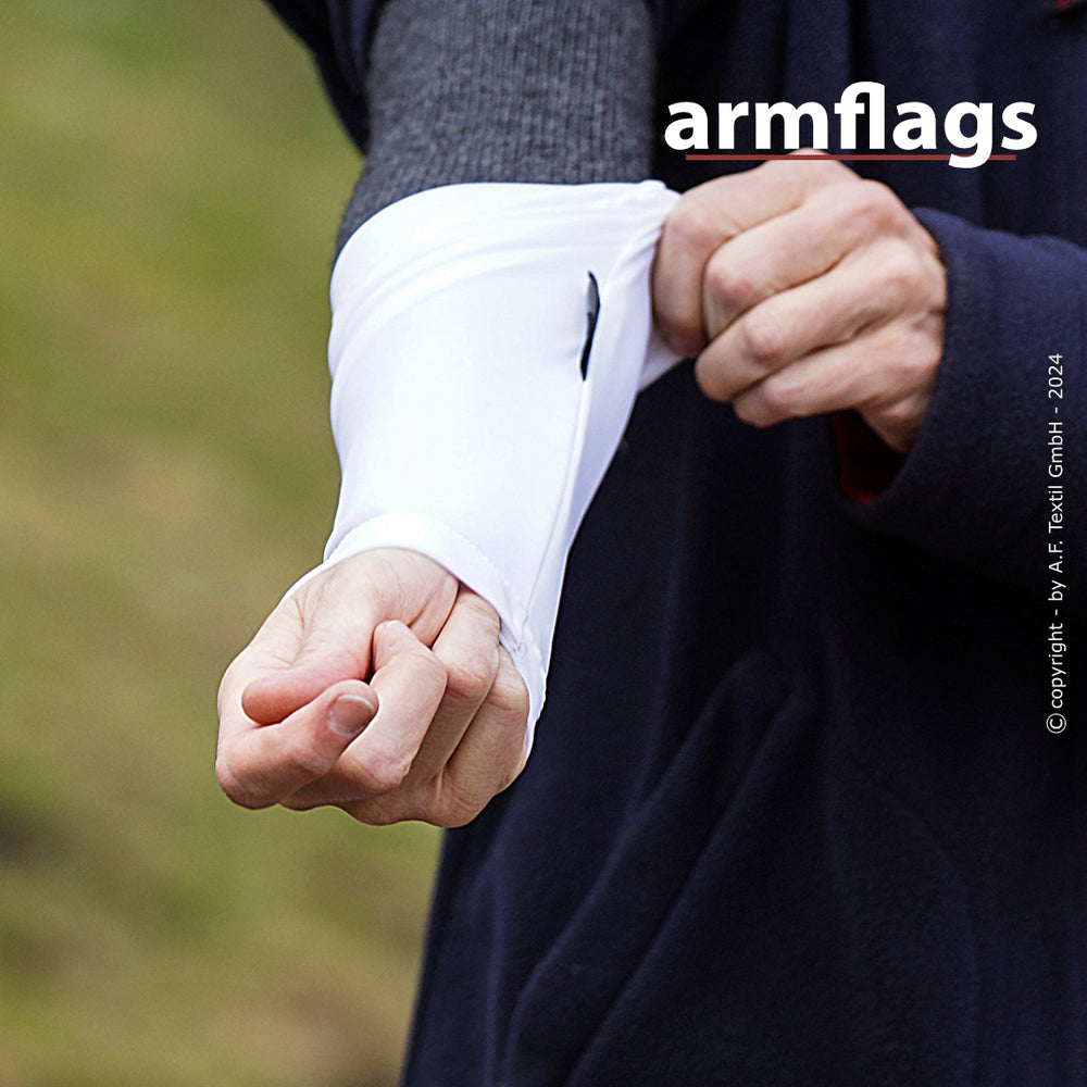 „Person zieht flexiblen weißen Ärmel an einem Kleidungsstück in unscharfer Outdoor-Umgebung an.“