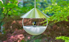Halbkugelförmige Vogeltränke aus grauem Material mit metallischem Dach, ideal für den Garten.