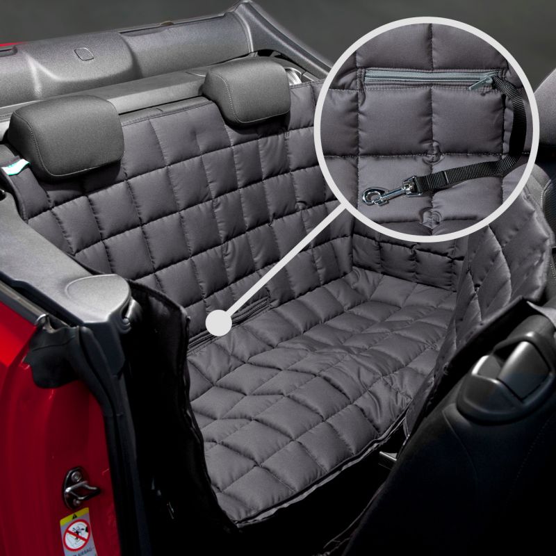 Gepolsterte Rücksitzbank eines Autos mit wasserfester, abnehmbarer Schondecke und Befestigungsriemen im Detail.