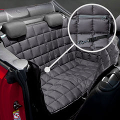 Gepolsterte Rücksitzbank eines Autos mit wasserfester, abnehmbarer Schondecke und Befestigungsriemen im Detail.