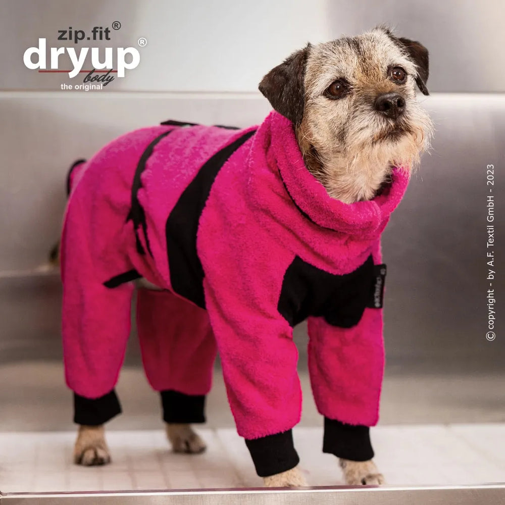 Kleiner Hund im pinken, flauschigen Ganzkörperanzug von Dryup® BODY zip.fit®, der warm und trocken bleibt.