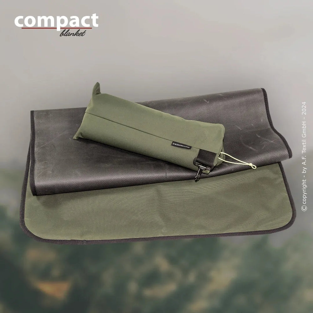 Kompakte Decke in runden Beutel, auf dunkler Oberfläche präsentiert, ideal für unterwegs und Outdoor-Aktivitäten.