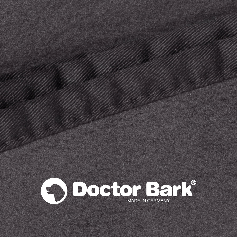 Graue Fleece-Kuscheldecke mit glänzender schwarzer Naht und "Doctor Bark"-Logo, gefertigt in Deutschland.