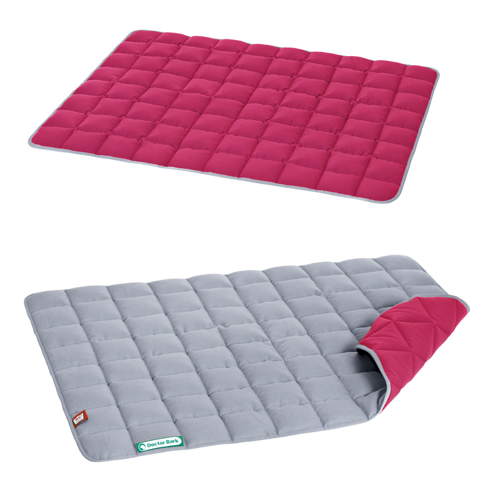 Gesteppte Wendedecke mit roter Oberseite und grauer, wendbarer Unterseite für vielseitige Nutzung.