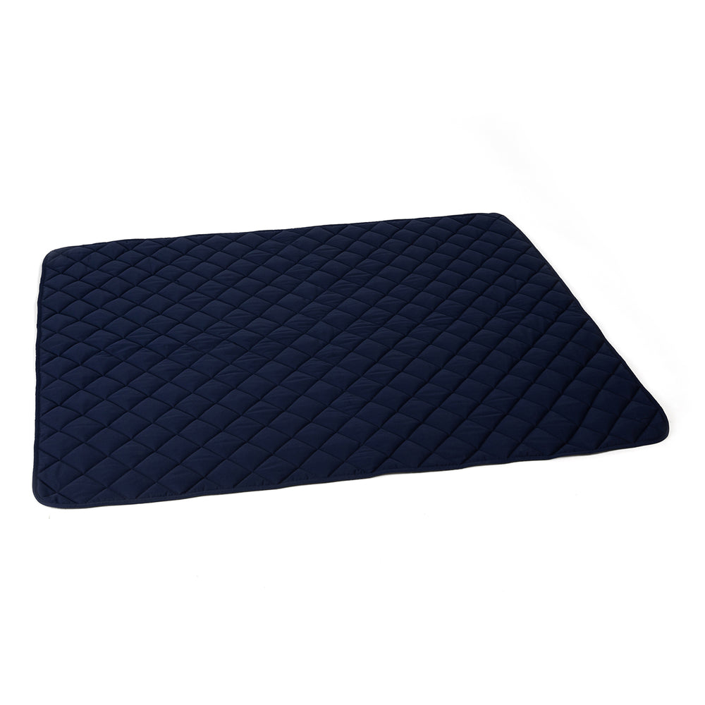 Dunkelblaue Steppdecke aus Fleece mit diagonalen Nähten und abgerundeten Kanten für hohen Komfort und Gemütlichkeit.