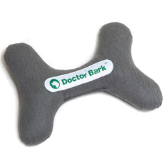 Graues Hundespielzeug in Knochenform mit "Doctor Bark"-Logo, hergestellt aus weichem Material für Hunde.