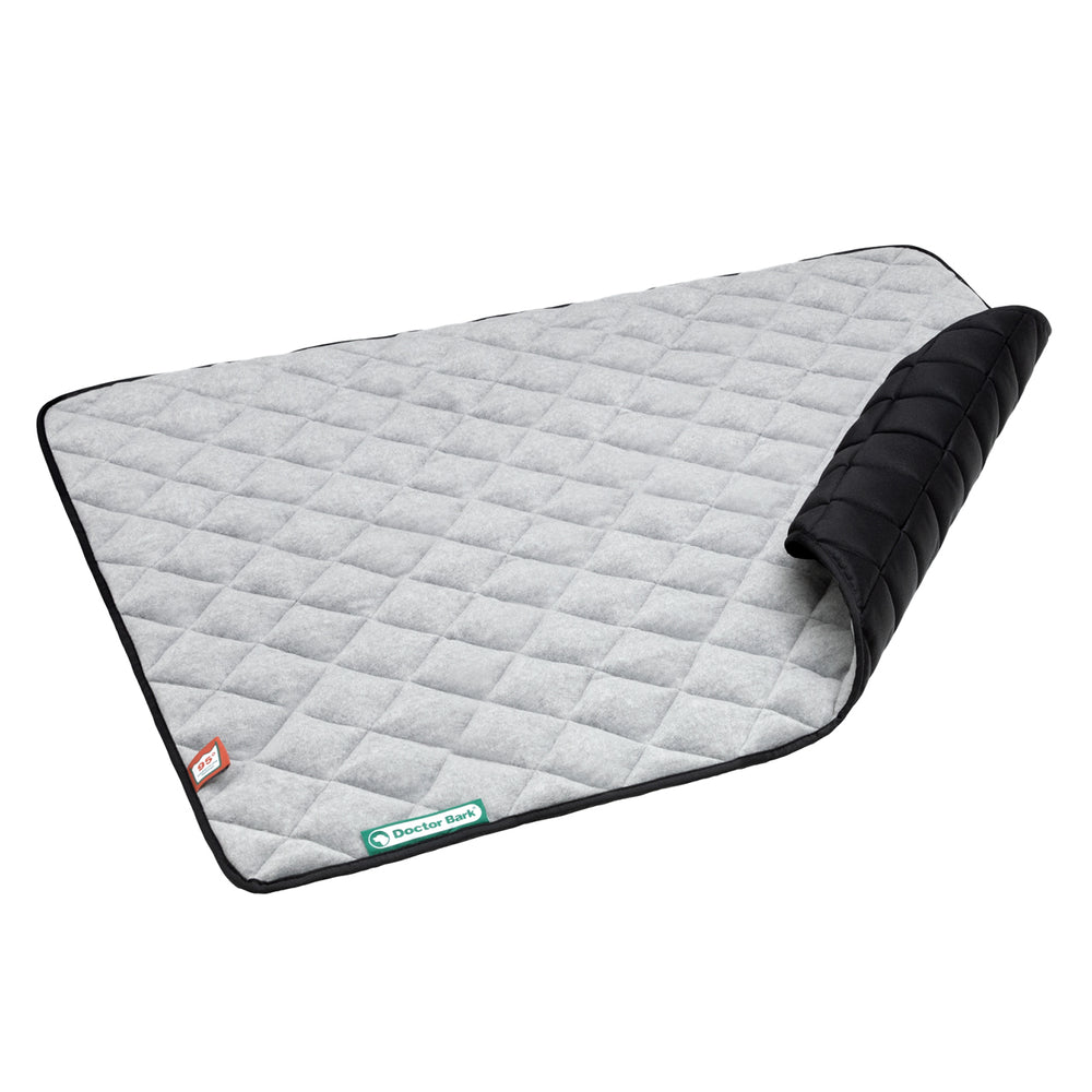 Hellgraue Steppdecke aus Fleece mit schwarzem Rand, ideal für den Innenbereich oder als bequeme Unterlage.