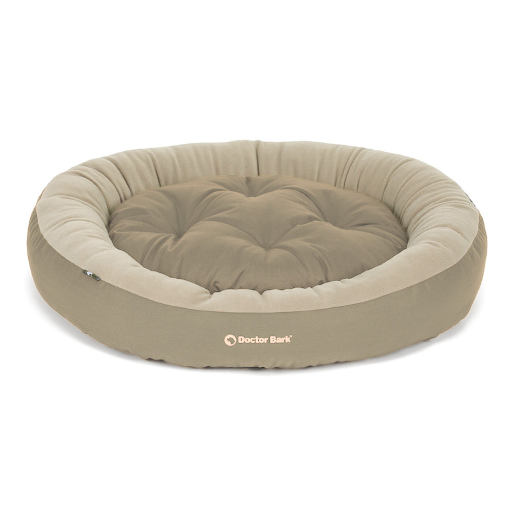 Beiges rundes Hundebett mit gepolsterter Liegefläche für optimalen Komfort und abgerundeten Seiten.
