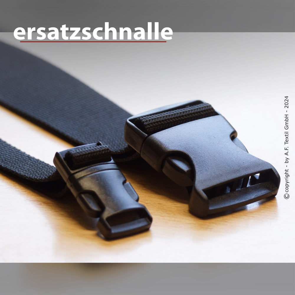 "Zwei schwarze Ersatzschnallen aus Kunststoff mit Stoffband, eine größer, eine kleiner, auf hellem Hintergrund."