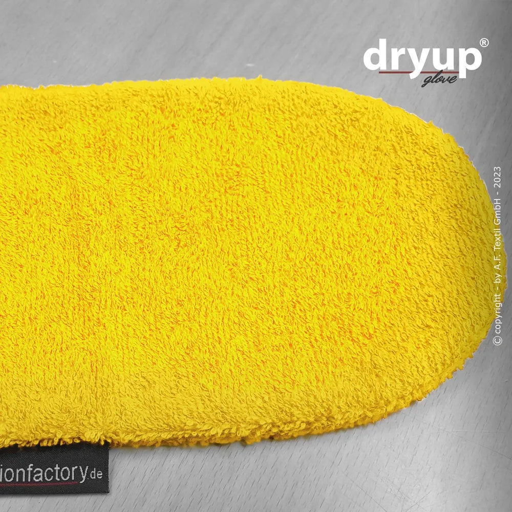 "Gelber flauschiger Reinigungshandschuh Dryup® mit strukturierter Oberfläche auf grauem Holzuntergrund."