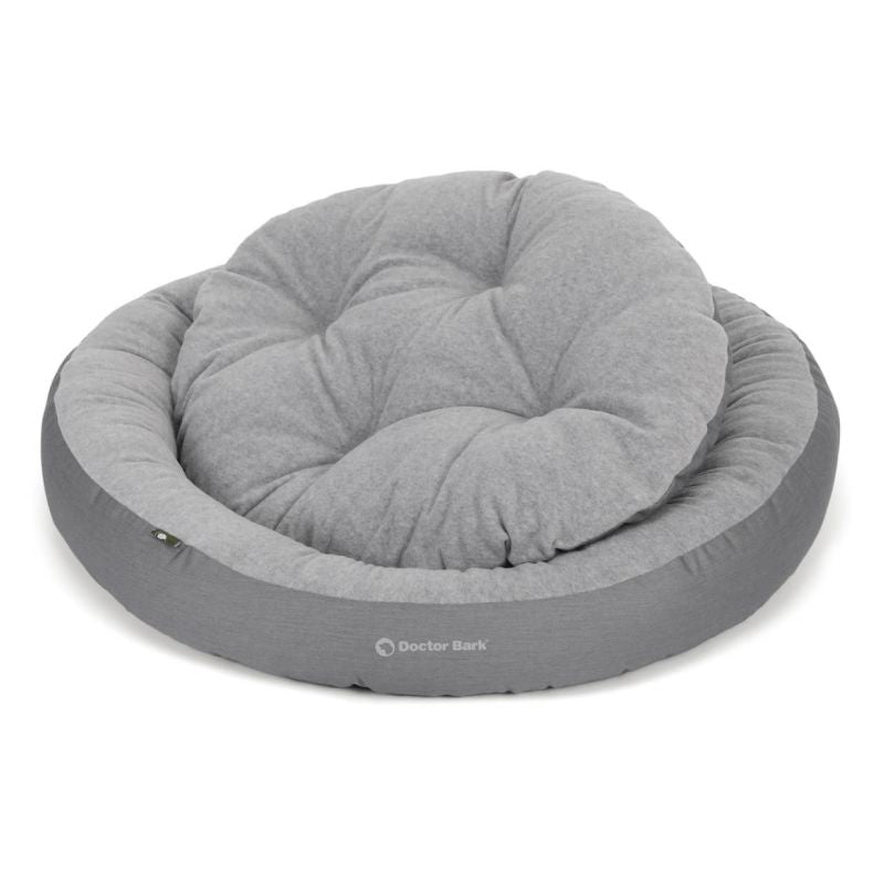 Graues, rundes Hundebett aus strapazierfähigem Material im gemütlichen Design für Hunde.