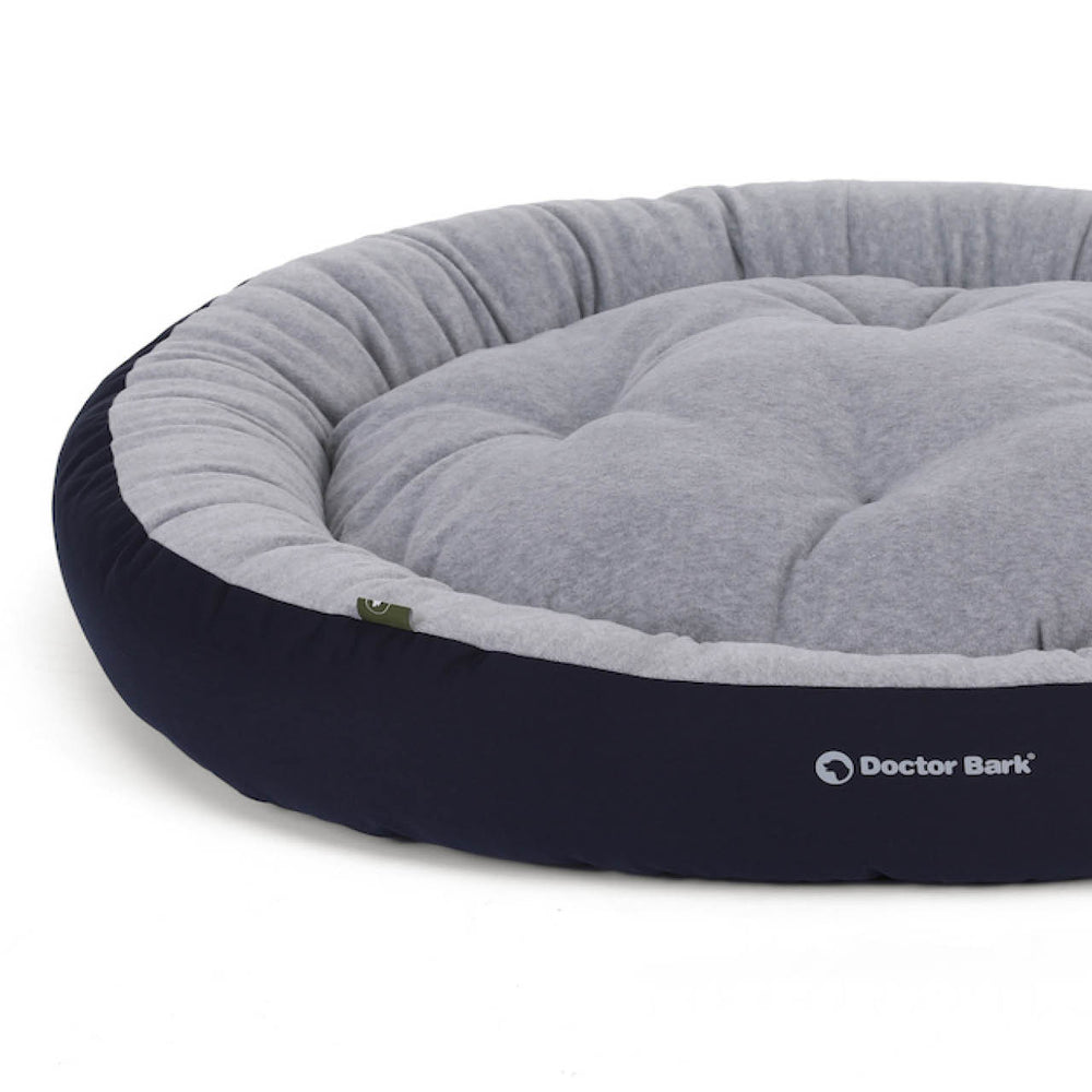 Bequemes rundes Hundebett in grau mit dunkelblauem Rand für optimalen Komfort von Haustieren.