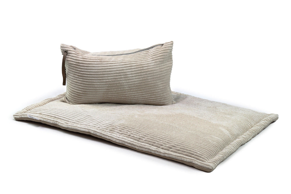 "Komfortable Hundereisedecke aus Cord in sanften Beigetönen mit gestreiften Kissen für entspannte Reisen."