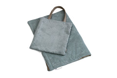 Weiche, gestreifte Hundereisedecke in Grautönen mit passender Tasche und Henkel, ideal für unterwegs.