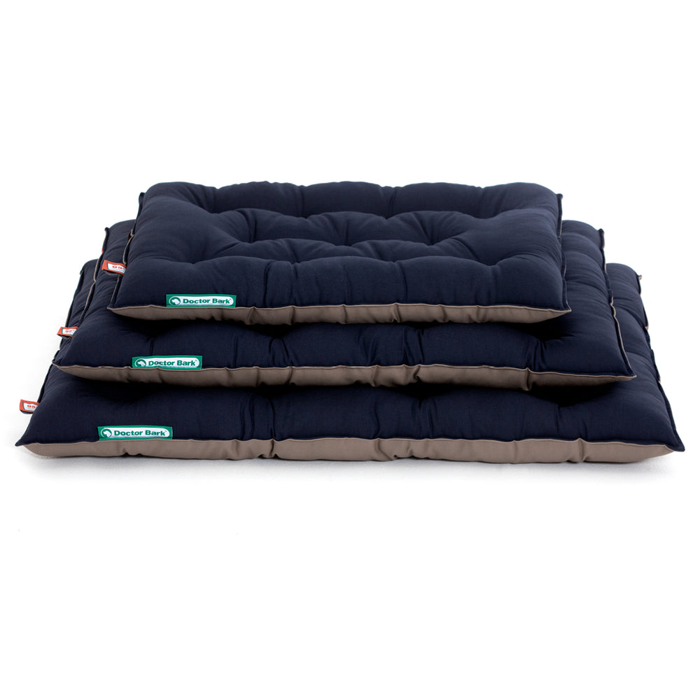 Drei gestapelte hundefreundliche Kissen in navy und beige mit markanter Steppung für optimalen Komfort.