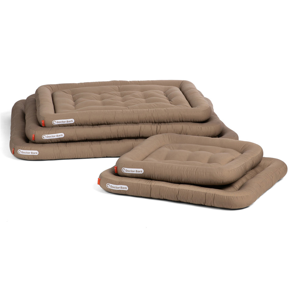 Orthopädische Lounge-Kissen für Hunde in verschiedenen Größen, gepolstert und in neutralem Braunton.