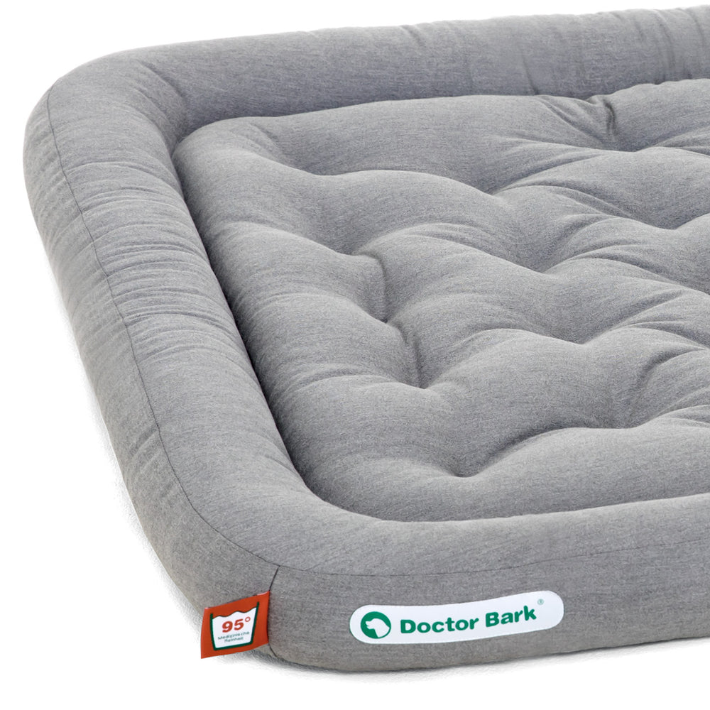 Graues, gepolstertes Hundekissen mit abgerundeter Form und gestepptem Design, ideal für orthopädische Pflege.