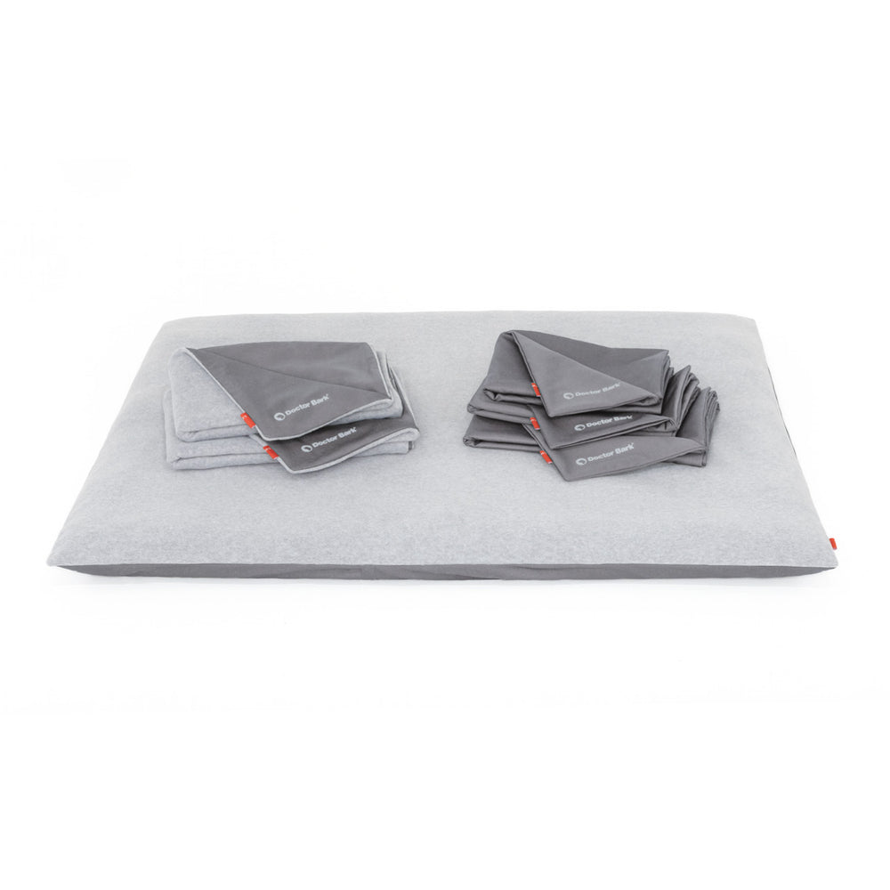 Graues Doctor Bark Fleece Cover Kissen mit gestapelten Handtüchern in ähnlichem Farbton für optimale Gemütlichkeit.