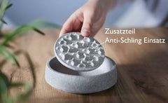 Handgehaltener Katzennapf Granicium mit Anti-Schling-Einsatz in grauer, strukturierter Oberfläche.