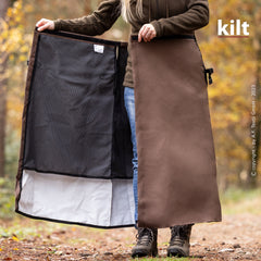 Person im Freien hält einen braunen Kilt mit Netzinnenseite und wasserabweisender Schicht.
