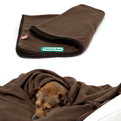 "Braune Doctor Bark Kuscheldecke aus Fleece, weich gefaltet, mit entspanntem Hund darunter."