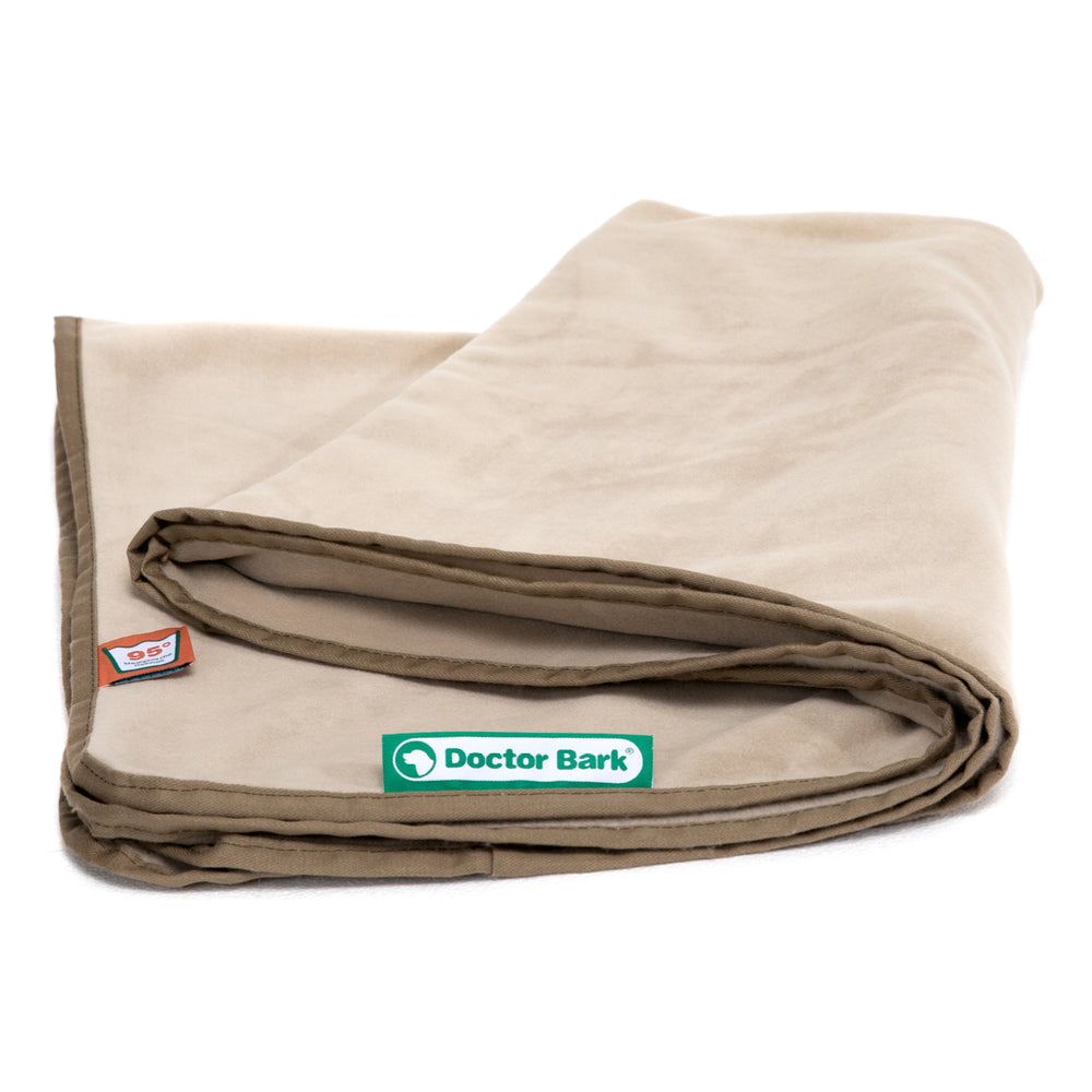 Beige Fleece Kuscheldecke von Doctor Bark mit grünem Etikett und dunklem braunem Rand, ordentlich gefaltet.