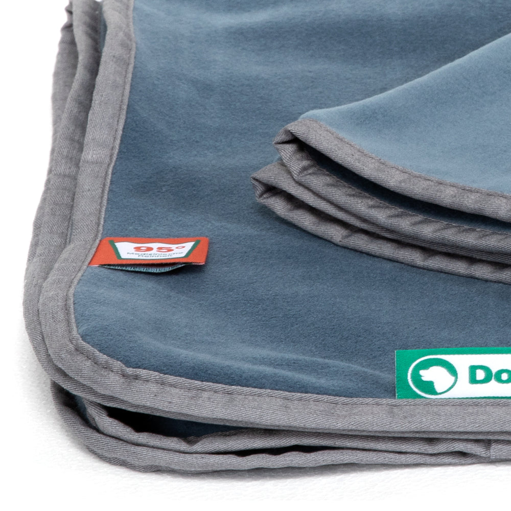 "Faltbare graue Doctor Bark Kuscheldecke aus Fleece mit heller Einfassung und Markenetikett in der Ecke."