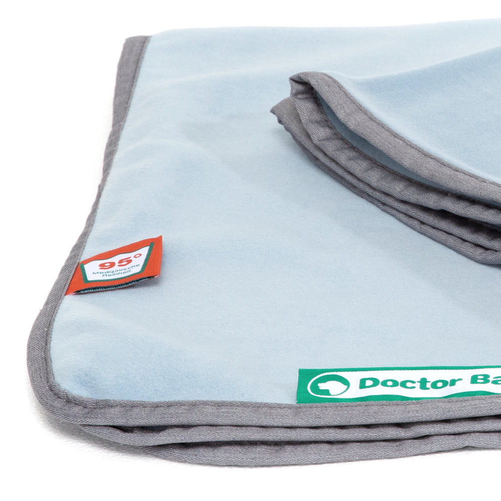 Weiche, blaue Doctor Bark Kuscheldecke aus Fleece mit grauen Kanten und grünem Logo in der Ecke.