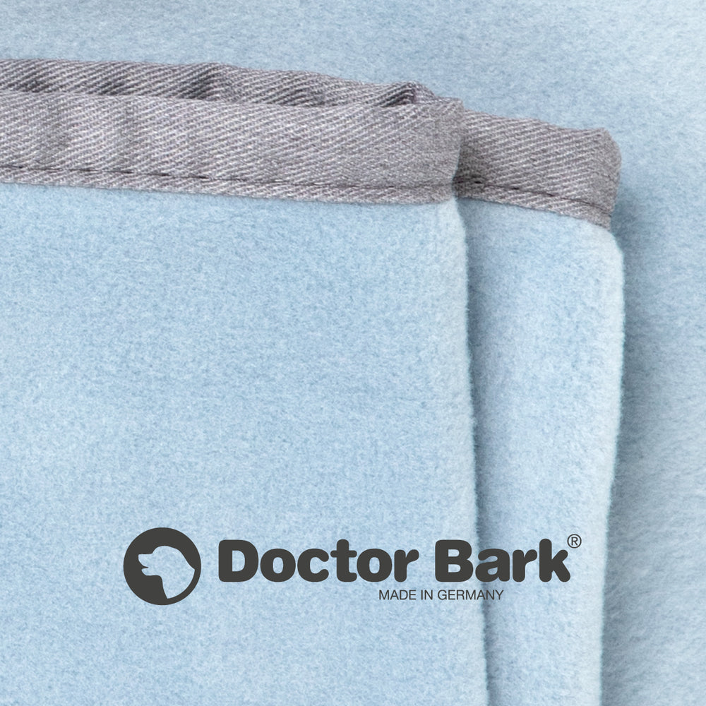 Hellblaue Fleece-Kuscheldecke von Doctor Bark mit grauem Rand und Logo, hergestellt in Deutschland.