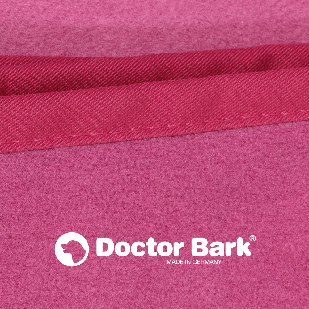 Pinkfarbene Doctor Bark Kuscheldecke aus Fleece mit glatter Textur und Logo "MADE IN GERMANY".
