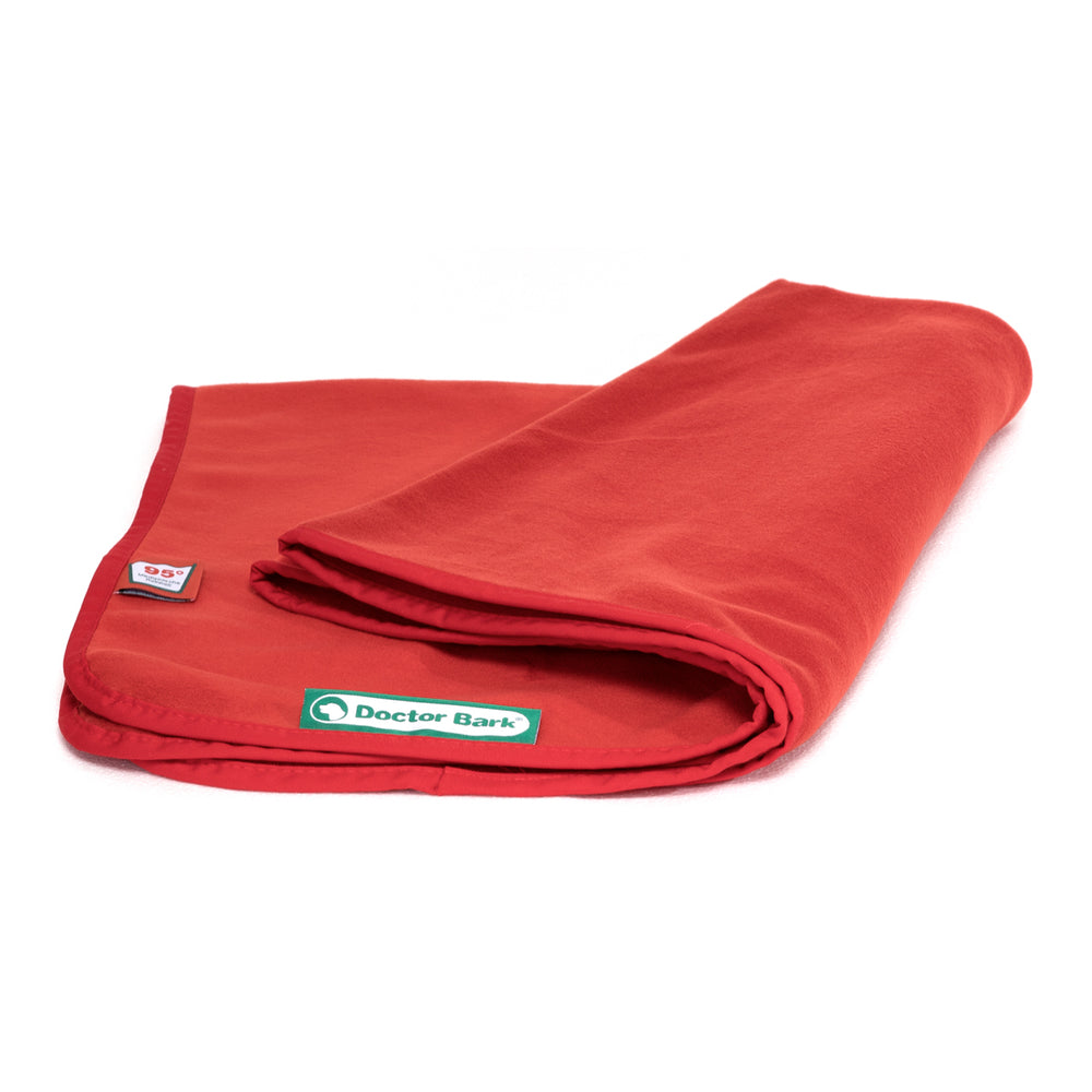 Rote Fleece-Kuscheldecke von Doctor Bark, leicht zusammengerollt mit grünem Logo in der Ecke.