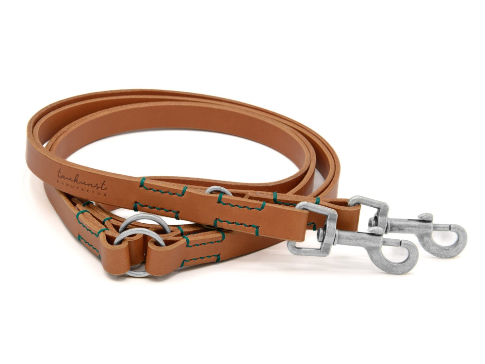 Braune doppelt geflochtene Lederleine mit grünen Nähten und zwei Karabinern, ideal für Hundebesitzer.