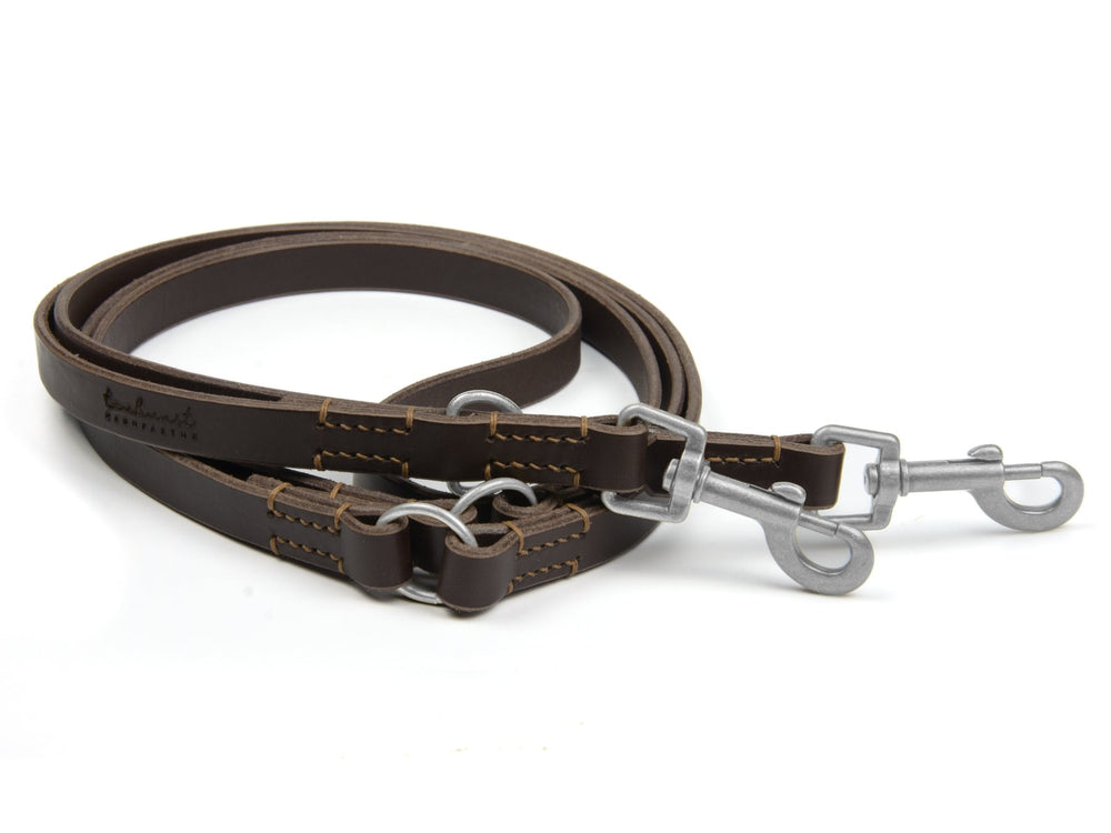 Doppelte Hundeleine aus braunem Leder mit silbernen Karabinerhaken für Geschirr oder Halsband.