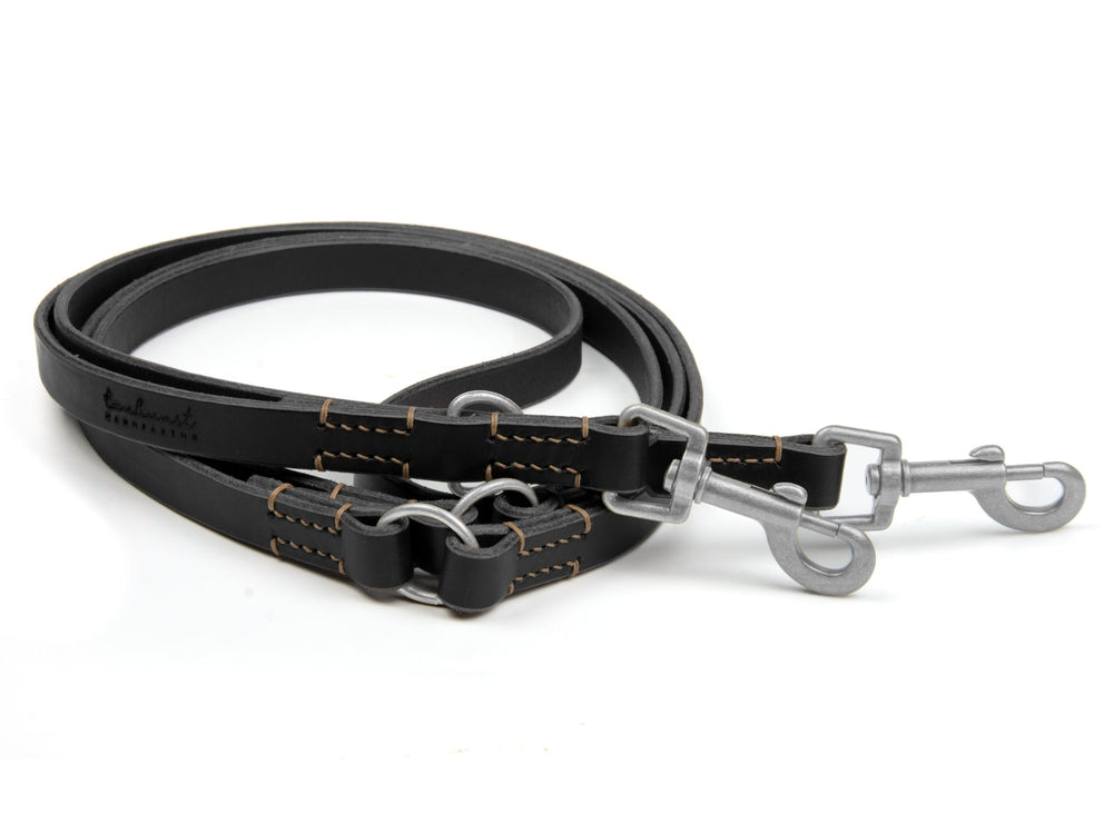 Schwarze Lederleine "Waldgeist" mit hellen Nähten und zwei stabilen Karabinerhaken, flexibel und robust.