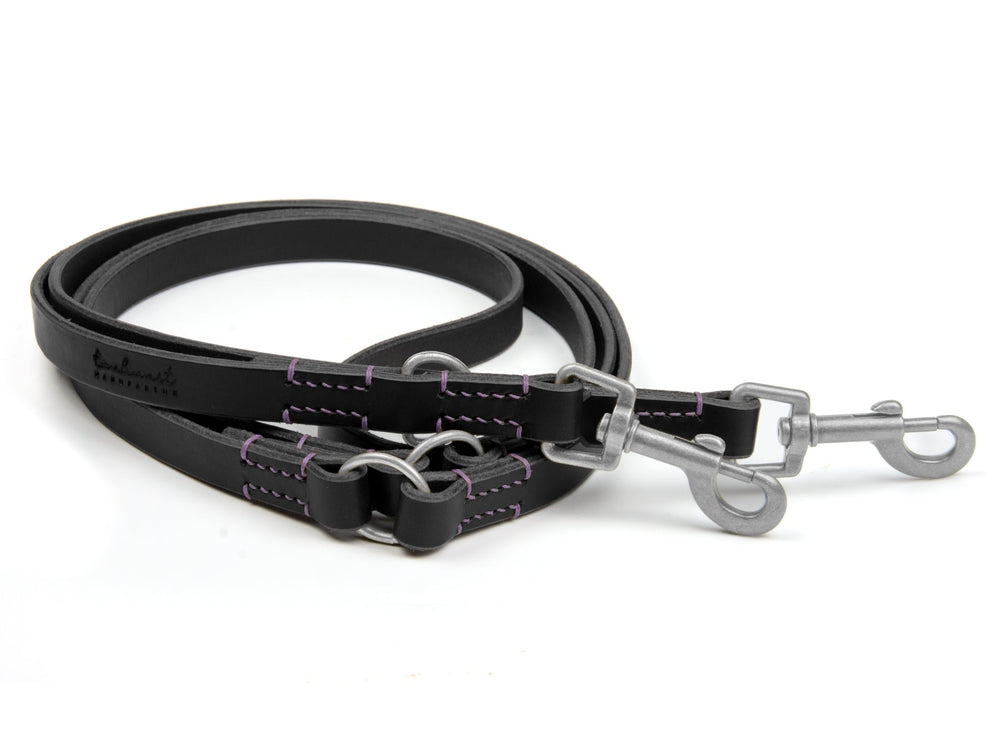 Schwarze Lederleine mit lila Naht und Edelstahlkarabinern, robust und flach, ideal für Hunde.