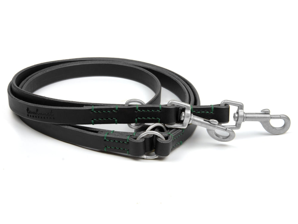 Schwarze Lederleine mit grünen Nähten und zwei Karabinerhaken, robust und langlebig für Hunde.