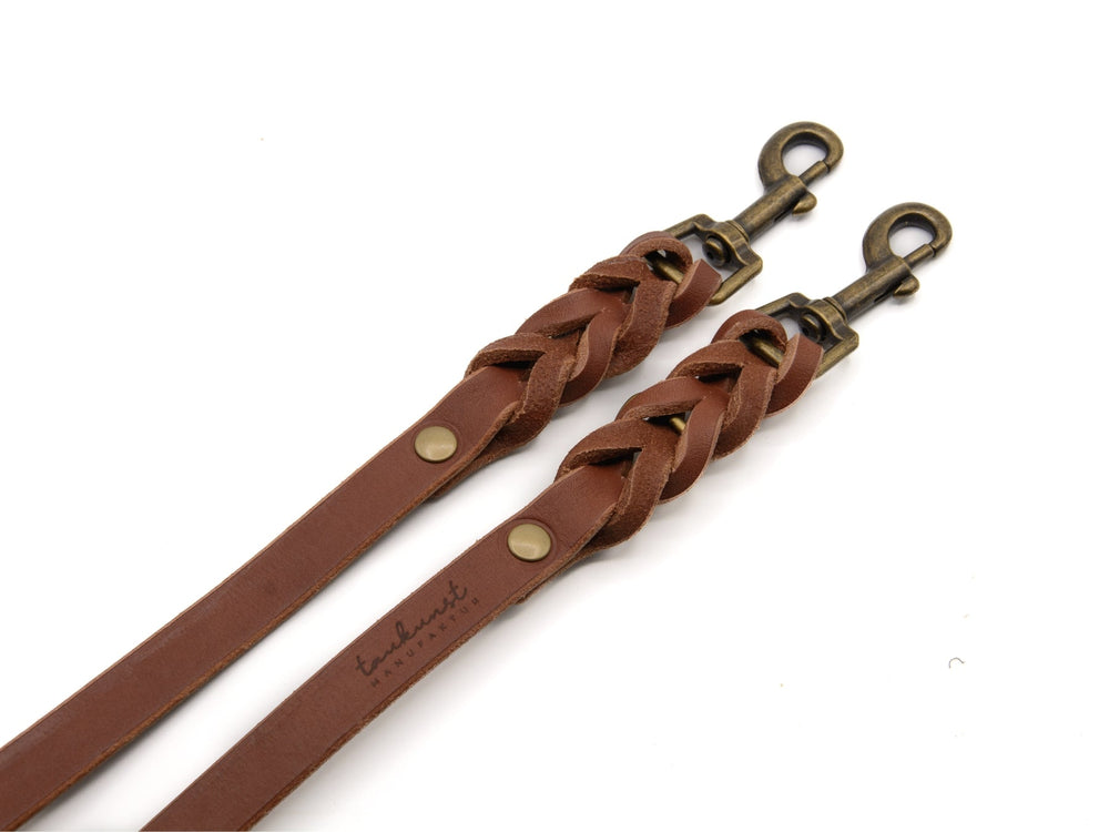 Braune, geflochtene Lederleine mit Nieten und zwei robusten Metallhaken für Hunde. Hochwertig und langlebig.