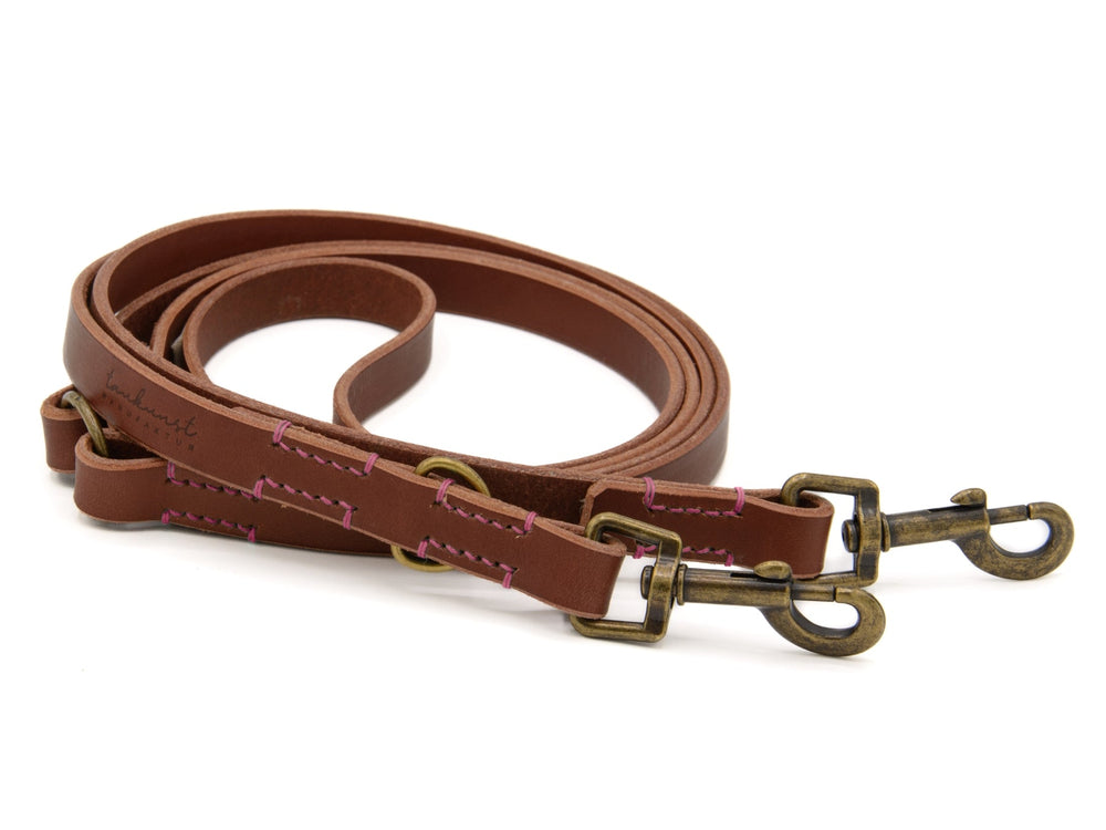 Braune Lederleine "Waldgeist" mit zwei Karabinerhaken und bunten, pinken Nähten für stilvolle Hundebesitzer.