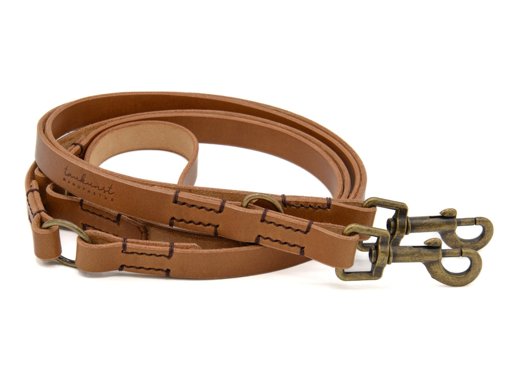 Braune Lederleine mit zwei Karabinerhaken, stabil genäht, für sichere Spaziergänge mit deinem Hund.